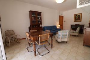 a living room with a wooden table and chairs at Charming Otranto Apartment Turchese Air Con Covered Parking in Otranto