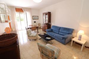 a living room with a blue couch and a table at Charming Otranto Apartment Turchese Air Con Covered Parking in Otranto