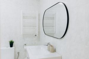 a white bathroom with a mirror and a sink at Um pe na praia in Figueira da Foz +41 photos