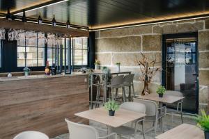 a restaurant with tables and chairs and a bar at Quinta Casal da Silva 1951 in Magrelos
