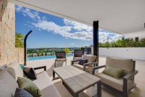 una sala de estar con un sofá y una mesa en Piso de lujo con piscina privada en las Colinas, en Orihuela Costa