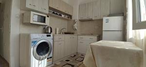 a kitchen with a washing machine and a refrigerator at Апартамент Калоян in Banya