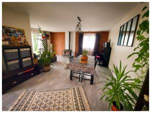 un soggiorno con un tavolo e alcune piante di Chambre dans grande maison paisible a Paulhan