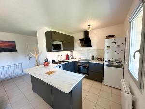 a kitchen with blue cabinets and a white refrigerator at Les Gemmeurs - T2 proche du lac in Aureilhan