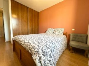 a bedroom with a bed and a chair at Les Gemmeurs - T2 proche du lac in Aureilhan