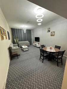 a living room with a table and chairs and a couch at sweet home 2 BHK apartment in Ajman 