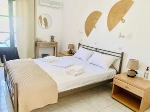 a bedroom with a bed with white sheets and pillows at Skopelos Inn in Stafylos