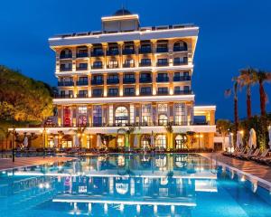 ein Hotel mit einem Pool vor einem Gebäude in der Unterkunft Serenity Queen Hotel in Alanya