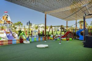 ein Kinderspielplatz mit Rutschen und Schaukeln in der Unterkunft Serenity Queen Hotel in Alanya