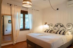 a bedroom with a large bed and a window at Casa Nurru in Orosei