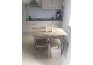 a kitchen with a wooden table and chairs in it at Ferienhaus Käthe-Kollwitz in Eckernförde +7 photos