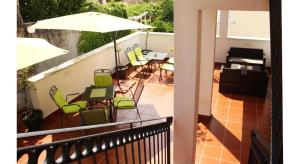 a balcony with chairs and tables and an umbrella at Guest House Sol 1 in Cavtat
