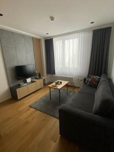 ヤホリナにあるApartman Aurora - Aparthotel Zlatni Javorのソファとテーブルのあるリビングルーム