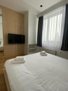 ヤホリナにあるApartman Aurora - Aparthotel Zlatni Javorの大きな白いベッドとタオルが2枚置かれた寝室