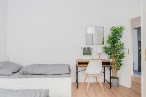 a bedroom with a bed and a desk with a chair at Ferienwohnung Markranstädt - Geräumige Apartments nahe Leipzig in Markranstädt