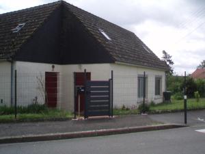 une petite maison blanche avec un toit noir dans l'établissement location Champagné, à Champagné