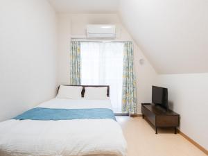 a bedroom with a bed and a tv and a window at Shinjuku/Shin-Okubo Sta 2min walk/Kabukicho 5 min in Tokyo