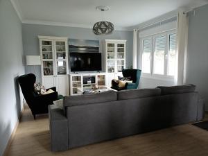 a living room with a couch and chairs and a tv at Casa do Olmo in Porto de Espasante +60 photos