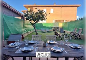 a wooden table with plates and glasses on a patio at DOMuum Holidays - CASA PUIGCERVER in Cambrils +36 photos