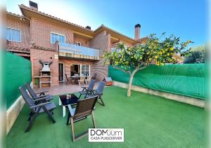 a backyard with chairs and a table and a tree at DOMuum Holidays - CASA PUIGCERVER in Cambrils