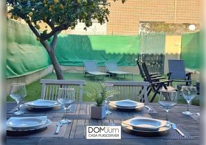 a table with plates and wine glasses on a patio at DOMuum Holidays - CASA PUIGCERVER in Cambrils