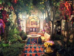 a living room with a table and trees and flowers at Riad Jnane d'Ô in Marrakesh