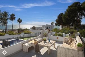 a patio with a table and chairs and the beach at Villa Mar Coral by Abahana Luxe in Moraira