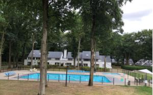 een zwembad voor een gebouw met bomen bij Vakantiebungalow BERK 1 in Aan de Wolfsberg