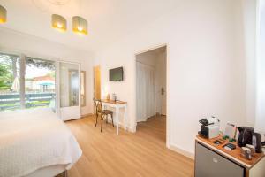 a bedroom with a bed and a desk and a table at Les Capucines Saint Tropez in Saint-Tropez