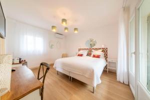 a bedroom with a white bed with red pillows at Les Capucines Saint Tropez in Saint-Tropez