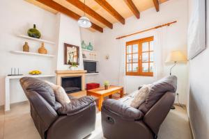 a living room with two chairs and a fireplace at Can Pascual Gran in Manacor