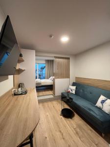 a living room with a blue couch and a bed at Suntel Łeba in Łeba