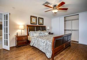 Un dormitorio con una cama y un ventilador de techo. en Villa Fieke, en Palm Desert