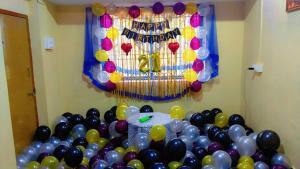 a room with a bunch of balloons and a happy birthday balloon wall at Royal Home Stay Honnavar in Kāsarkod +2 photos