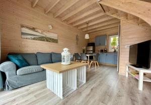 a living room with a blue couch and a table at Czerwone Domki in Dębki