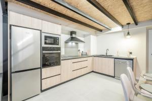 バレンシアにあるLoft HomeValenciaのキッチン(木製キャビネット、ステンレス製の電化製品付)