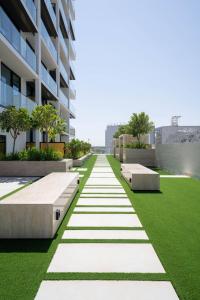an office building with green grass and benches at Elegant 1br Apt In Jvc With Spacious Balcony in Dubai