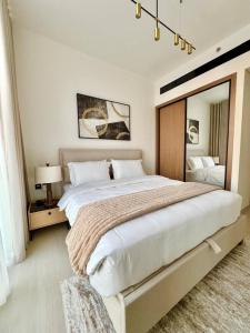 a bedroom with a large bed with a large mirror at Elegant 1br Apt In Jvc With Spacious Balcony in Dubai +27 photos