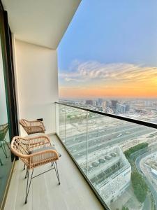 a balcony with two chairs and a view of the city at Elegant 1br Apt In Jvc With Spacious Balcony in Dubai