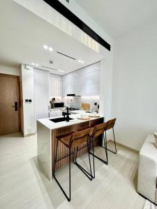 a kitchen with a island with two chairs and a sink at Elegant 1br Apt In Jvc With Spacious Balcony in Dubai