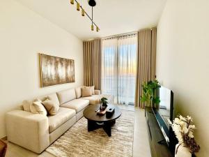 a living room with a couch and a coffee table at Elegant 1br Apt In Jvc With Spacious Balcony in Dubai