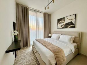 a bedroom with a bed and a desk and a window at Elegant 1br Apt In Jvc With Spacious Balcony in Dubai