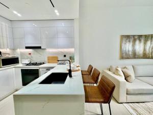 a kitchen and living room with a couch and a table at Elegant 1br Apt In Jvc With Spacious Balcony in Dubai