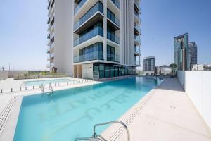 a swimming pool in front of a building at Elegant 1br Apt In Jvc With Spacious Balcony in Dubai