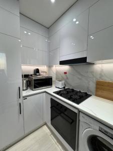 a kitchen with white cabinets and a stove top oven at Elegant 1br Apt In Jvc With Spacious Balcony in Dubai