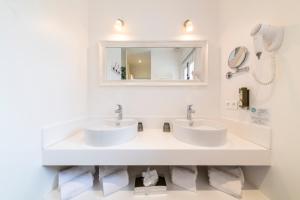 a bathroom with two sinks and a mirror at Les Capucines Saint Tropez in Saint-Tropez