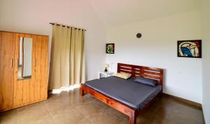 a bedroom with a bed and a wooden door at wild grove resorts in Varagampadi