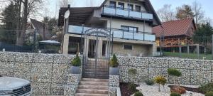 una casa dietro un muro di pietra con una recinzione di Chata Domaša David a Bžany
