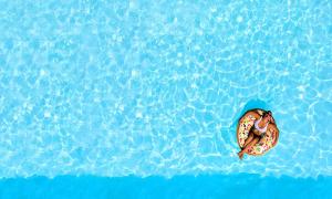 a person laying on aogie board in the water at Cretan Breeze Villa Beheizter Privater Swimmingpool in Dhrámia
