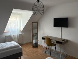 a bedroom with a desk with a television and a bed at City Nest Ettlingen - nähe Wasenpark in Ettlingen
